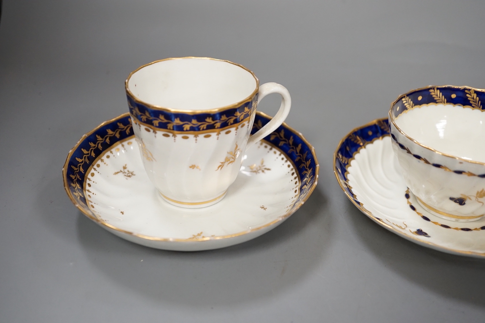 Three flight Worcester shankered teawares two coffee cup and saucers with blue borders and a teabowl and saucer similar c.1790